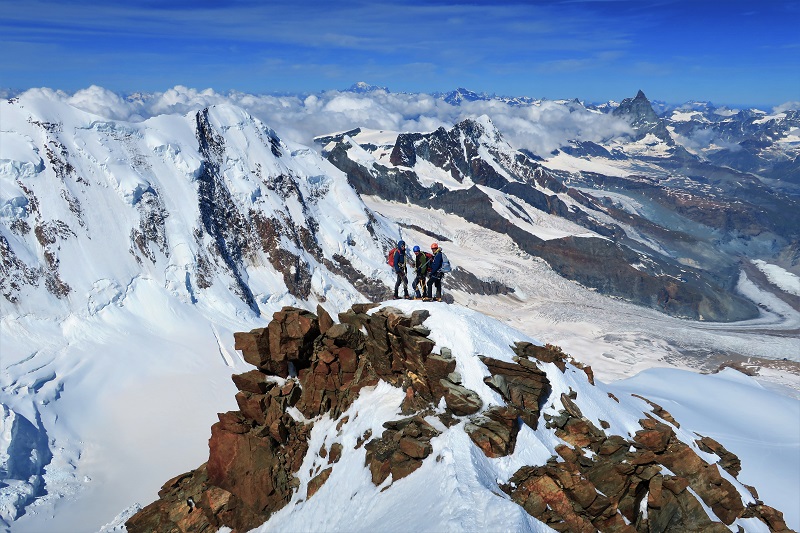 Descending the summit ridge with Lyskamm and Matterhorn in the background